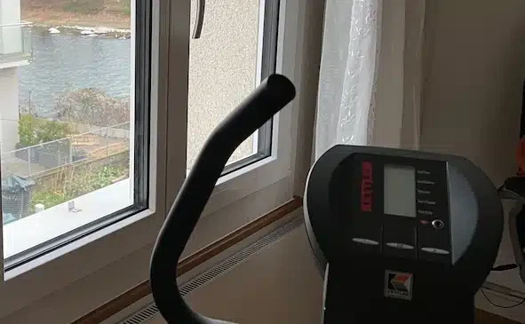 Ein Ausschnitt von einem Hometrainer und der Blick auf einen Fluss.